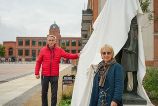 Prof. Dr. Eva Maria Kohl (r.) und Oberbürgermeister Volker Holuscha (l.) enthüllen die Plastik „Französischer Bergarbeiter und Flöhaer Spinnerin/Flöha/Mericourt“ auf dem Marktplatz in Flöha. Foto: Stadtverwaltung Flöha/ Erik Frank Hoffmann