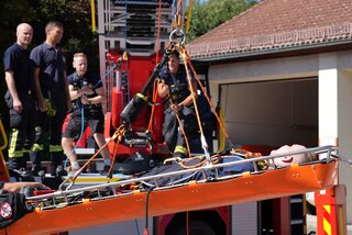 Bei der Produktvorführung wurden Leinen mit Umlenkrollen und Sicherung an der Drehleiter befestigt und eine Person in einer Trage nach oben gezogen. Foto: Stadtverwaltung Flöha/ Erik Frank Hoffmann